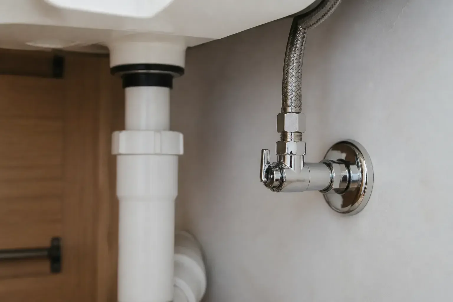 Clean under-sink plumbing connections and shutoff valve.