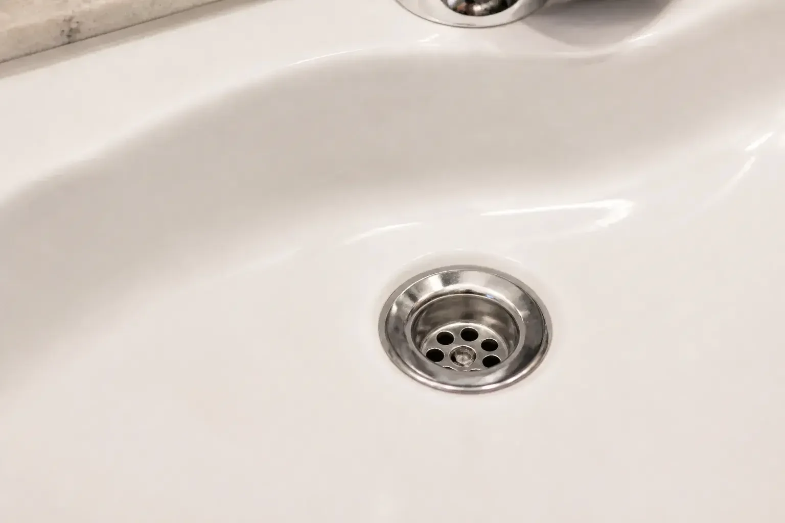 Unclogged bathroom sink drain in a clean basin.